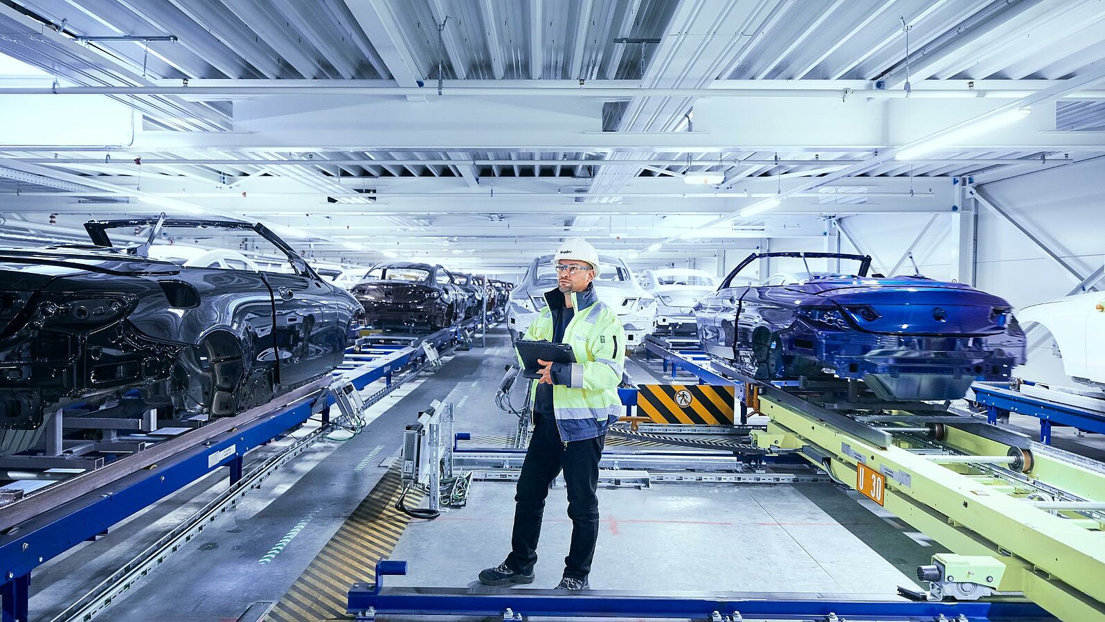 Leadec employee monitoring the automated conveyor technology using a tablet.