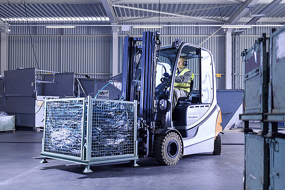 Ein Leadec-Mitarbeiter transportiert mit einem Gabelstapler eine Palette mit Abfall durch die Fabrik.