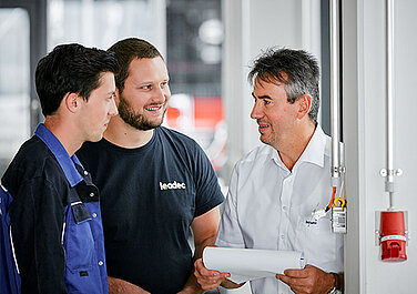 Two Leadec trainees in conversation with the trainer. 
