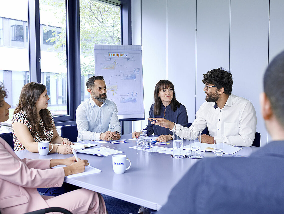 Group of Leadec employees at a meeting in conference room.