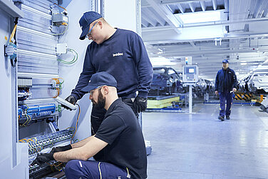 Zwei Leadec-Mitarbeiter bei der Fehleranalyse und Reparatur der installierten Elektronik.