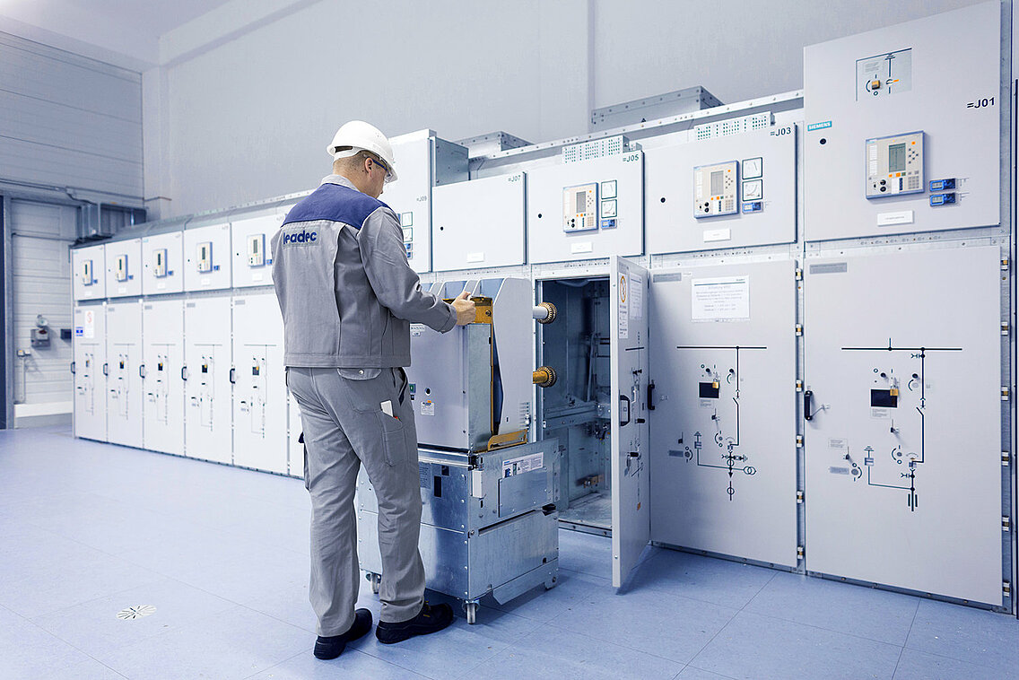Ein Leadec-Mitarbeiter bei der Installation einer Schaltanlage in einem Technikraum.