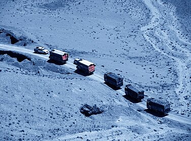 Konvoi von Lastwagen, die in der Wüste fahren. 