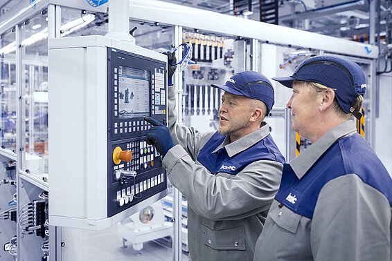 Zwei Leadec-Mitarbeiter überprüfen das Display einer Automatikstation.