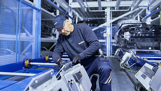 A Leadec employee replacing an inverter at a conveyor belt.